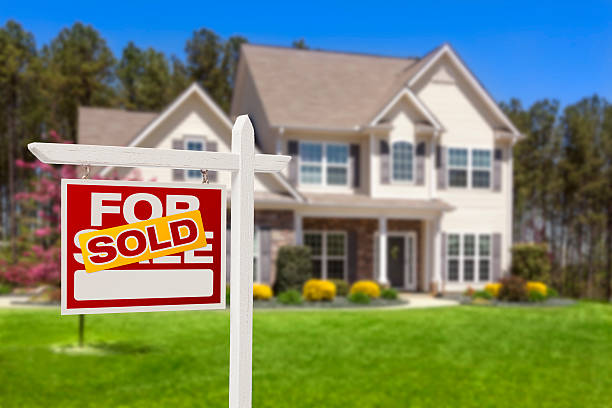New homeowners with conventional loan in front of suburban home